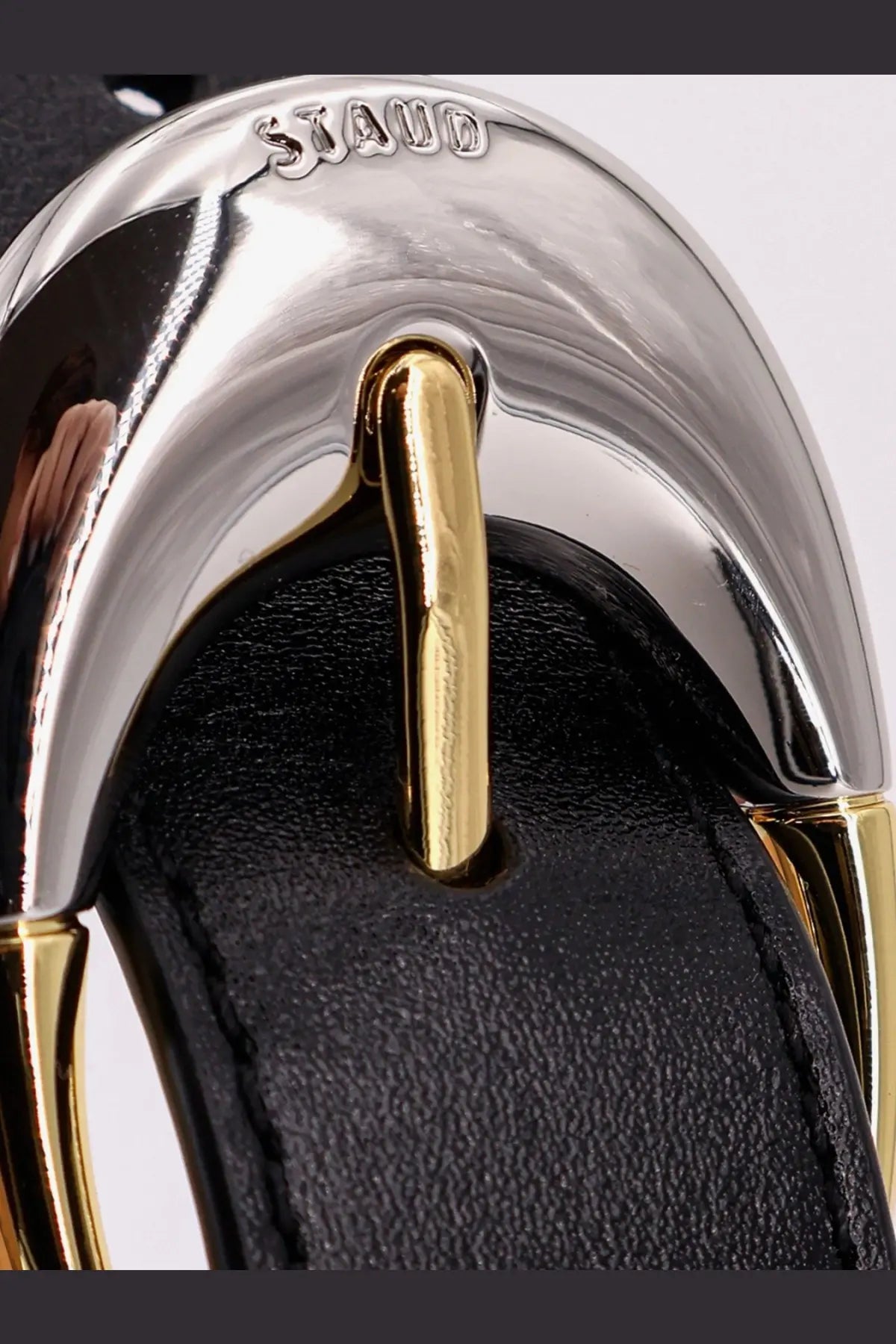 Silver and gold-tone metal buckle with black leather strap on staud women’s leather shoulder bag black