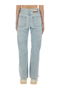 Back view of stella mccartney women’s light-wash denim cargo jeans with two back pockets and brown leather patch