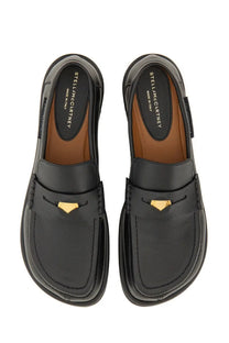 Stella McCartney women’s classic black leather loafers with gold-tone triangular accents on the front