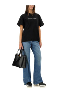 Black leather tote bag with top handles paired with stella mccartney women’s black cotton shirt