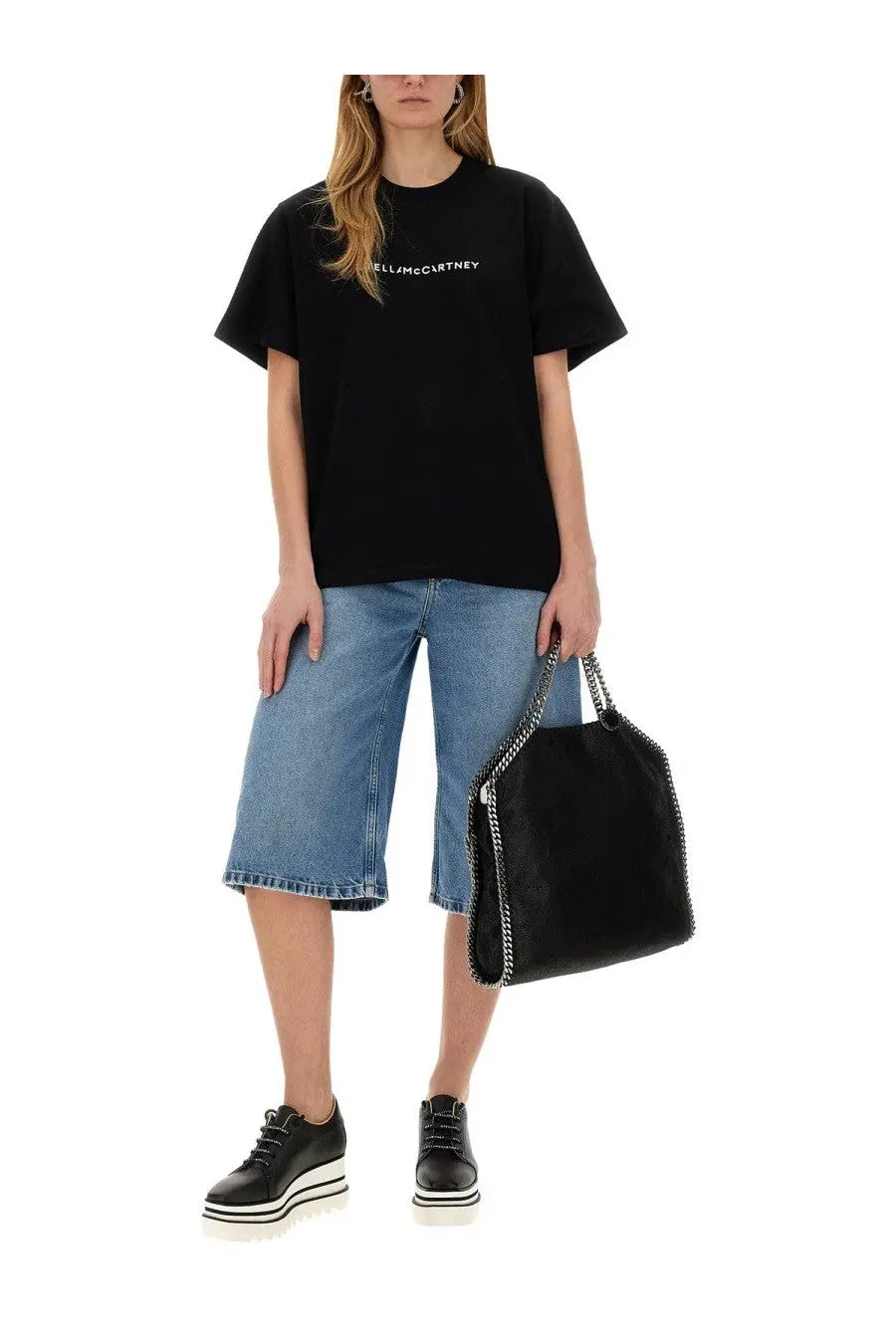Black leather shoulder bag with silver chain strap shown with stella mccartney women’s denim bermuda shorts blue