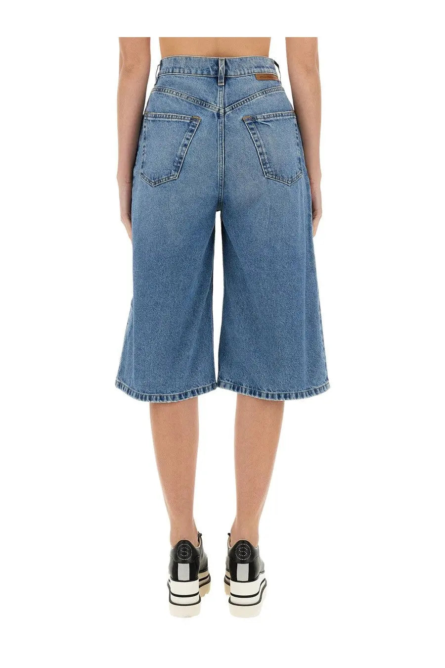 Stella mccartney women’s denim bermuda shorts in medium blue high-waisted culottes with flared leg and classic back pockets viewed from back