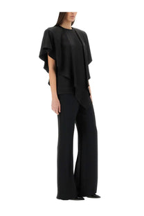 Stella McCartney women’s black draped top with flowing cape-like sleeves worn over matching wide-leg trousers