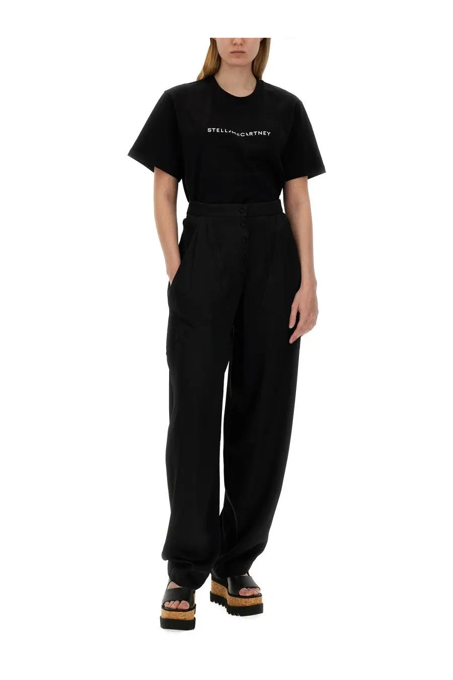 Black stella mccartney t-shirt with white lettering across the chest paired with high waist black pants for women