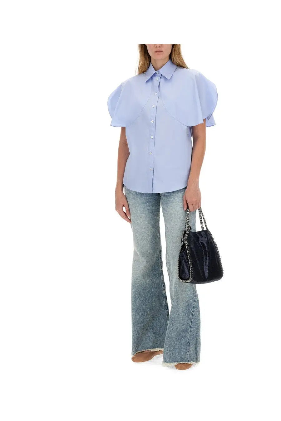 Black patent leather bucket bag with silver chain strap paired with stella mccartney women’s blue bootcut jeans