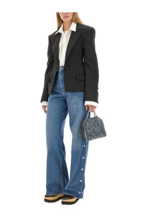 A small textured handbag with chain strap and silver embellishments paired with stella mccartney blue loose fit jeans