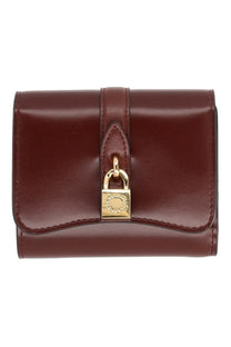 A sleek burgundy leather stella mccartney women’s portafoglio ryder trifold wallet with gold padlock closure and embossed logo