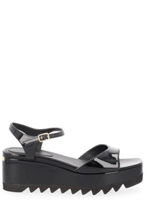 Stella McCartney women’s black patent leather platform sandal with gold-tone buckle and serrated sole front view