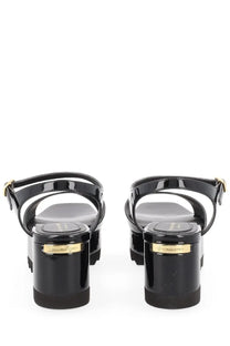 Black patent leather platform sandals by stella mccartney with gold-tone branding on the heel back view