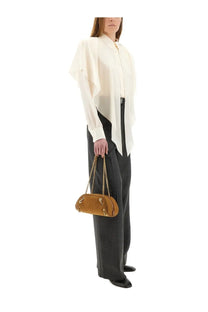 Tan suede oval handbag with gold-tone chain strap and hardware shown with stella mccartney white semi transparent shirt