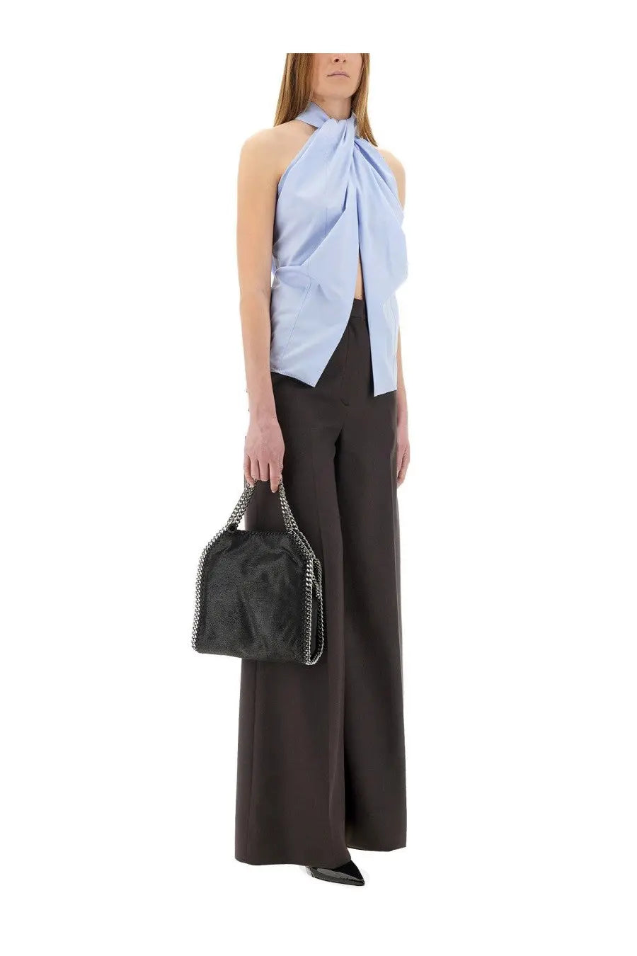 Black leather handbag with textured surface and silver chain strap paired with Stella McCartney blue sleeveless top