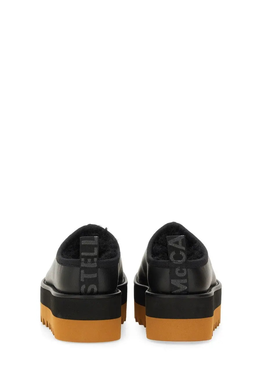 Black leather platform slip-ons with orange rubber sole and stella mccartney embossing on the back heel