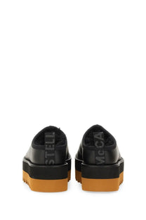 Black leather platform slip-ons with orange rubber sole and stella mccartney embossing on the back heel