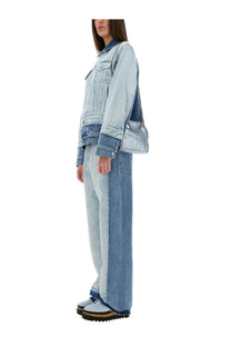 Stella McCartney women’s straight leg blue jeans paired with light blue denim jacket featuring silver chain strap and front flap pocket