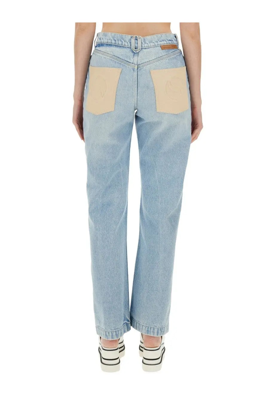 Stella McCartney women’s straight leg light-wash denim jeans with beige patch pockets and brown leather brand tab