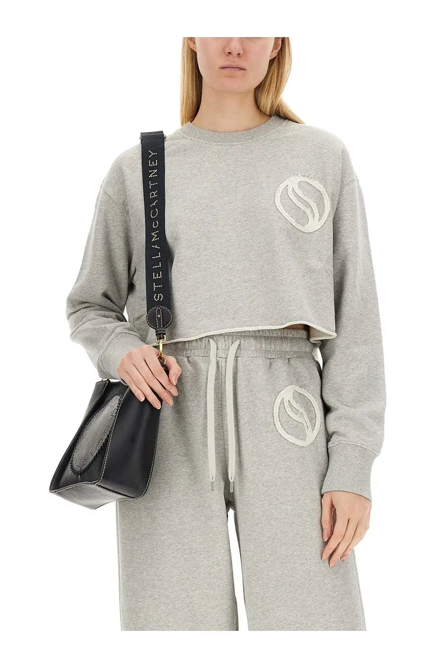 Black leather crossbody bag with long adjustable strap featuring stella mccartney logo in white lettering