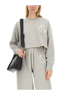 Black leather crossbody bag with long adjustable strap featuring stella mccartney logo in white lettering