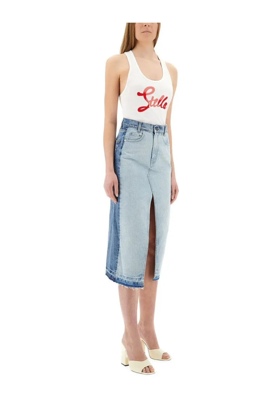 Light-wash denim midi skirt with front slit and frayed hem paired with stella mccartney white top