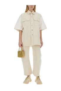 A small gold sequined handbag with a chain strap paired with stella mccartney women’s utility white jeans