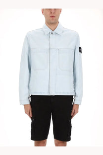 Stone Island men’s light blue denim jacket with two front pockets and black patch on left sleeve