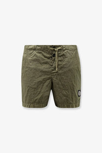 Stone Island men’s econylon swim trunks in olive green with drawstring waist and circular logo patch on lower right leg