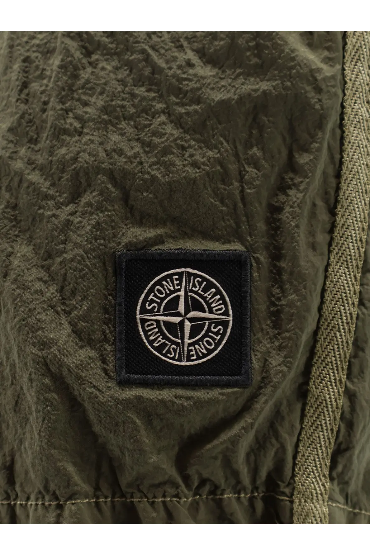 Olive green textured fabric patch with black embroidered stone island compass logo on men’s econylon swim trunks