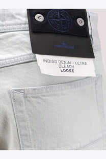 Stone Island men’s light-wash indigo denim jeans with black label and ultra bleach loose fit tag in blue faded effect