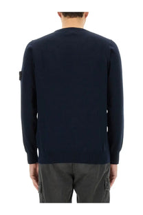 Stone Island men’s navy blue knit sweater with ribbed hem and cuffs featuring a black patch on the left sleeve