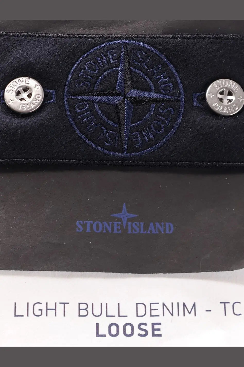 Dark blue stone island wallet made of light bull denim with embroidered compass logo and silver button fastenings