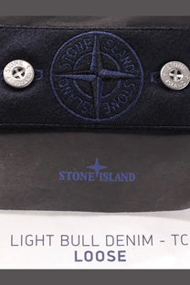 Dark blue stone island wallet made of light bull denim with embroidered compass logo and silver button fastenings