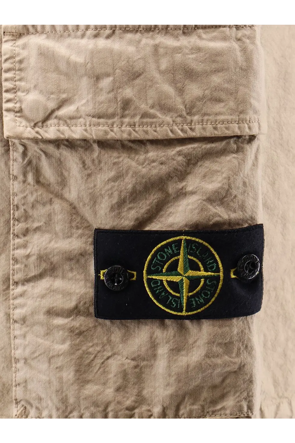Beige Stone Island men’s nylon shorts featuring a black patch with embroidered green and yellow compass logo