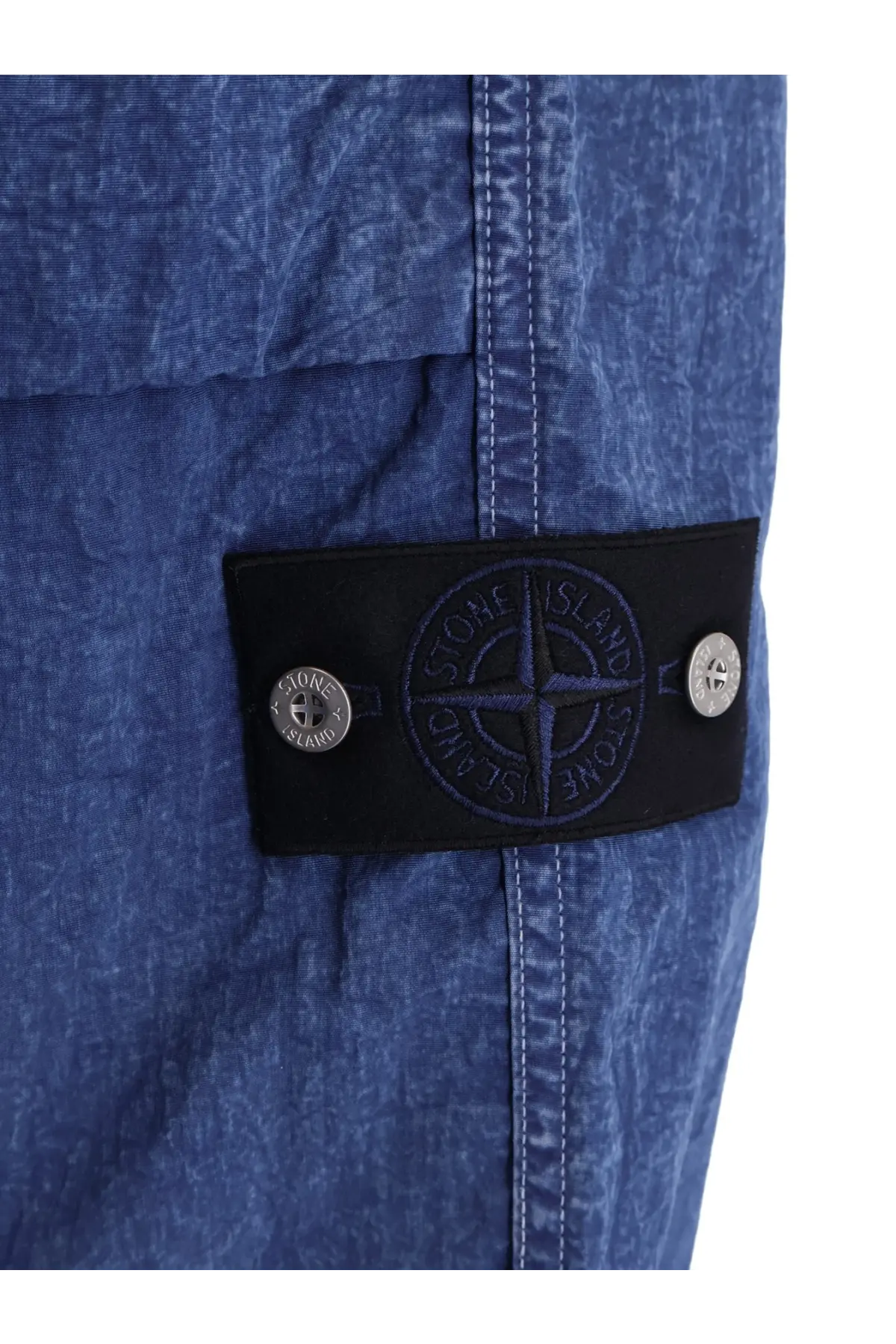Stone Island men’s blue nylon trousers with textured fabric black patch featuring compass logo and silver-tone buttons