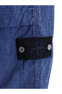 Stone Island men’s blue nylon trousers with textured fabric black patch featuring compass logo and silver-tone buttons