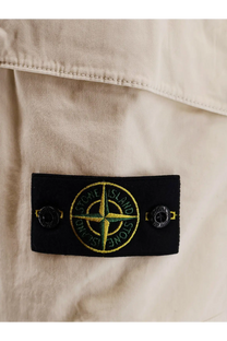 Black rectangular label with yellow and green Stone Island compass rose logo on men’s organic cotton white Bermuda shorts