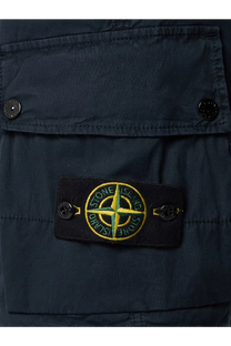 Dark navy stone island patch with yellow and green embroidered compass rose on black fabric on blue organic cotton shorts