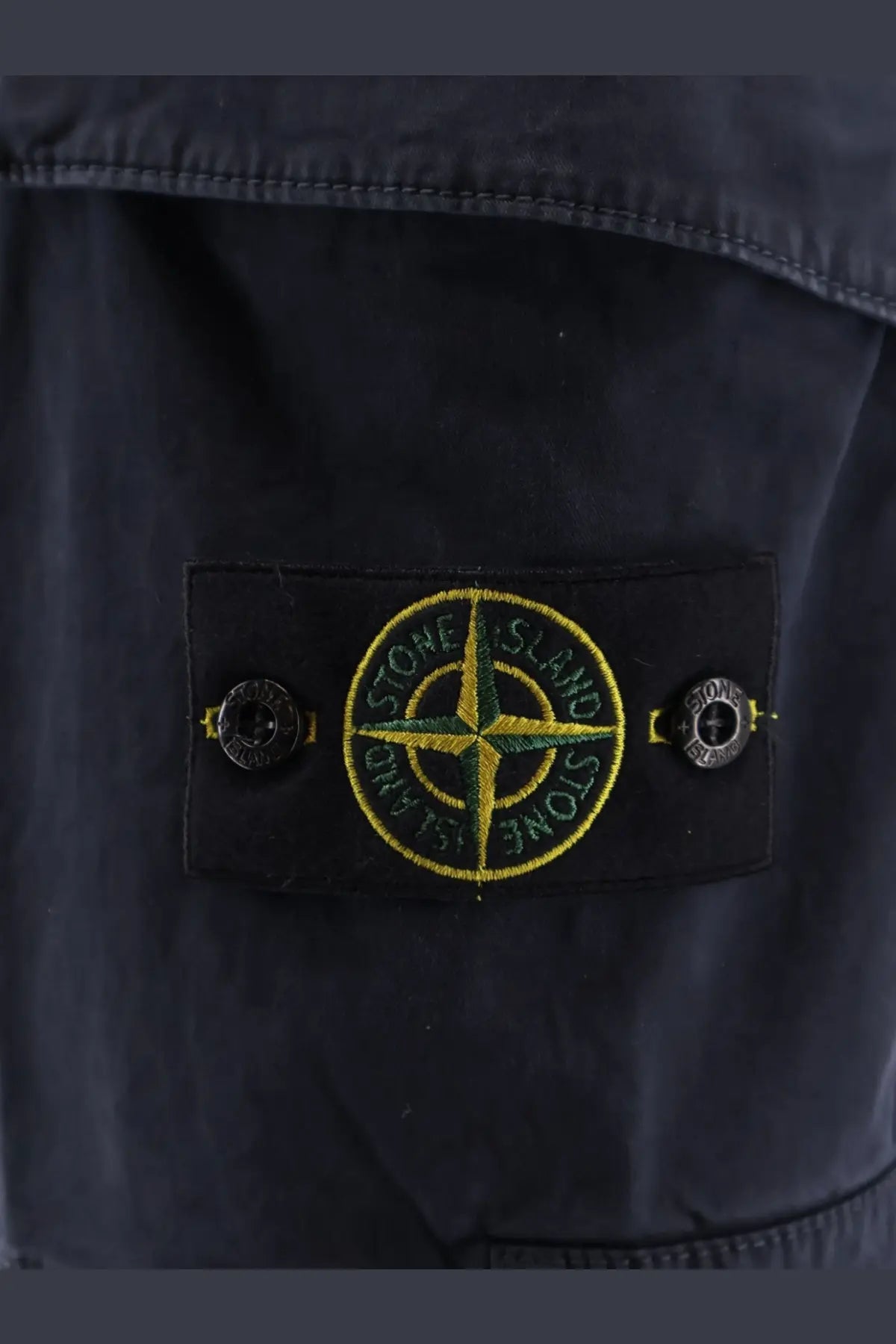 Black stone island patch with yellow and green embroidered compass rose on blue stone island mens organic cotton shorts