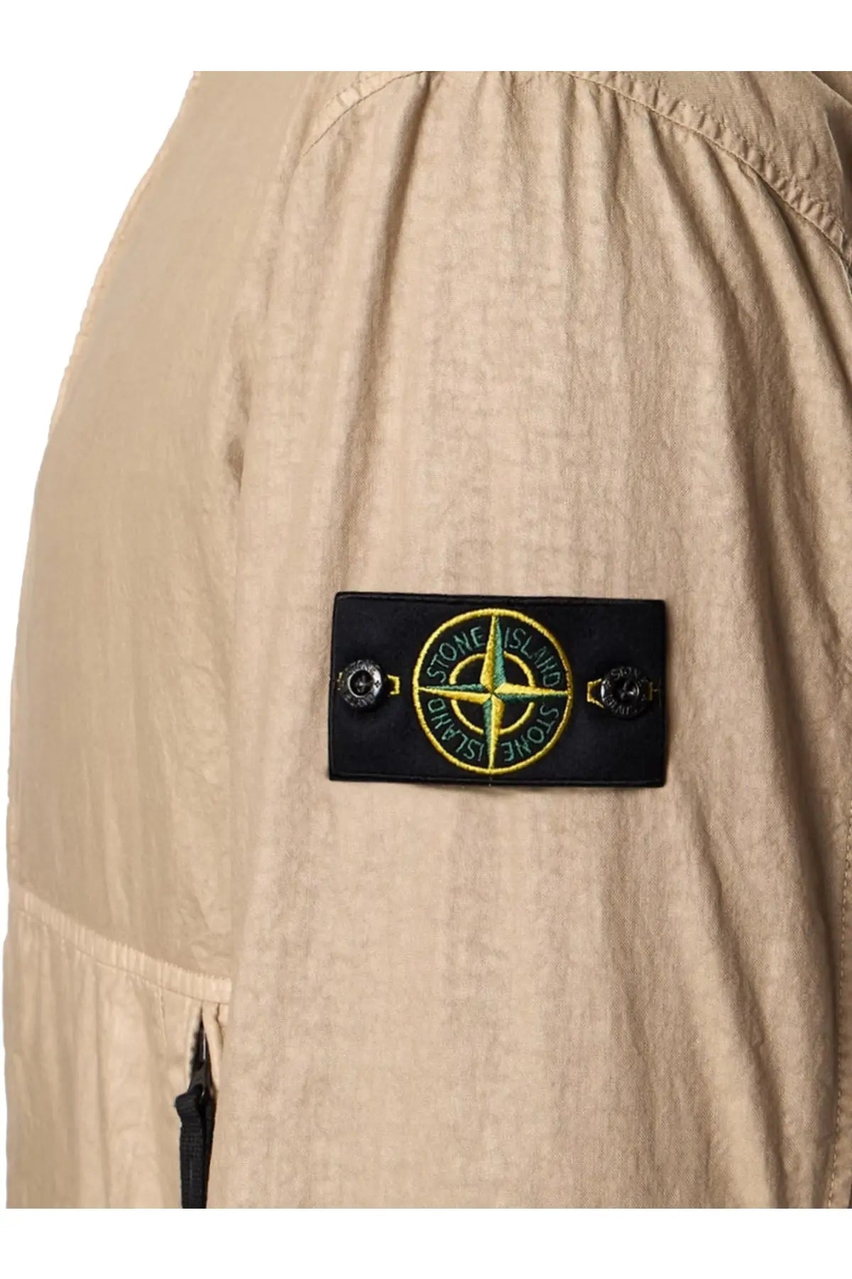 Beige stone island jacket sleeve patch with black background yellow compass rose and green stone island text on nylon panama jacket