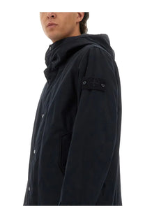 Black hooded jacket with subtle textured fabric and distinctive Stone Island brand patch on sleeve