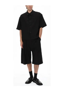 Studio Nicholson men’s black short-sleeved button-up shirt with relaxed fit and subtle pleats at the hem
