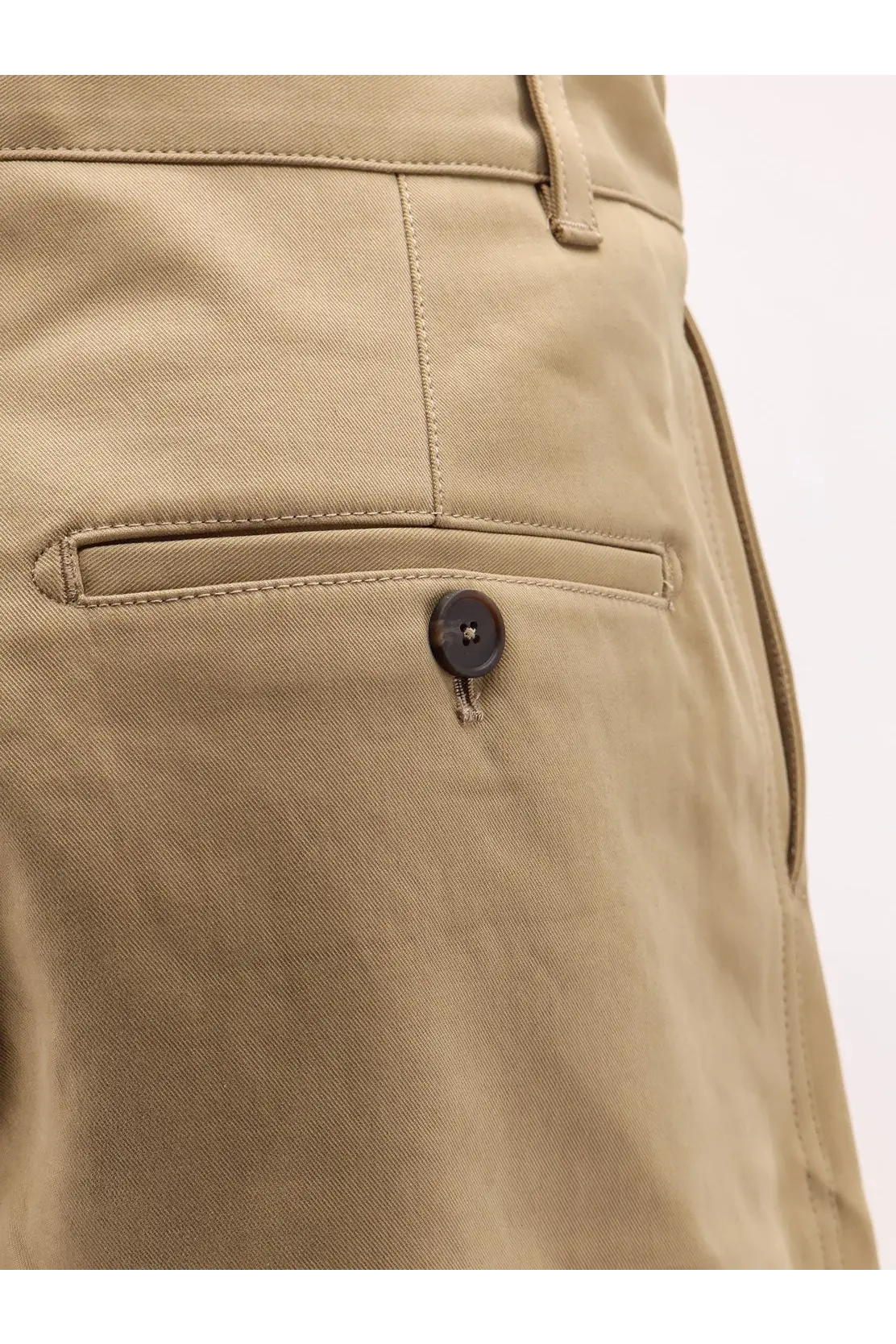Khaki cotton chino trousers by Studio Nicholson with a dark brown button on the front pocket for men