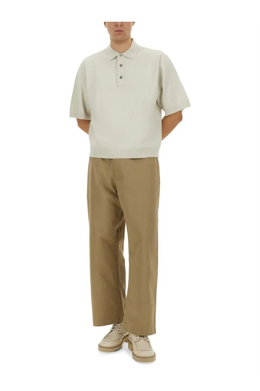 A light beige short-sleeved polo shirt with classic collar and three-button placket paired with studio nicholson men’s slim curved pants beige