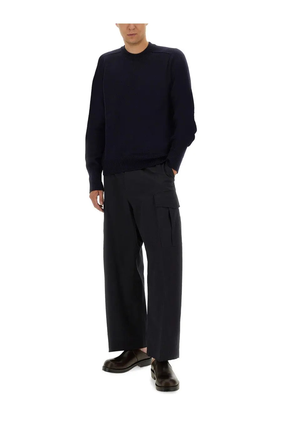 Studio Nicholson men’s wool jersey blue is a navy blue long-sleeved knit sweater with ribbed crew neckline and cuffs