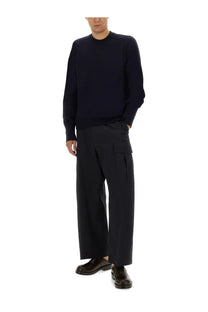 Studio Nicholson men’s wool jersey blue is a navy blue long-sleeved knit sweater with ribbed crew neckline and cuffs