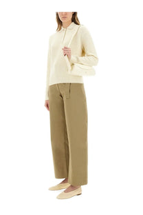 Studio nicholson women’s twill doring beige pants paired with a cream-colored ribbed knit polo sweater with button front
