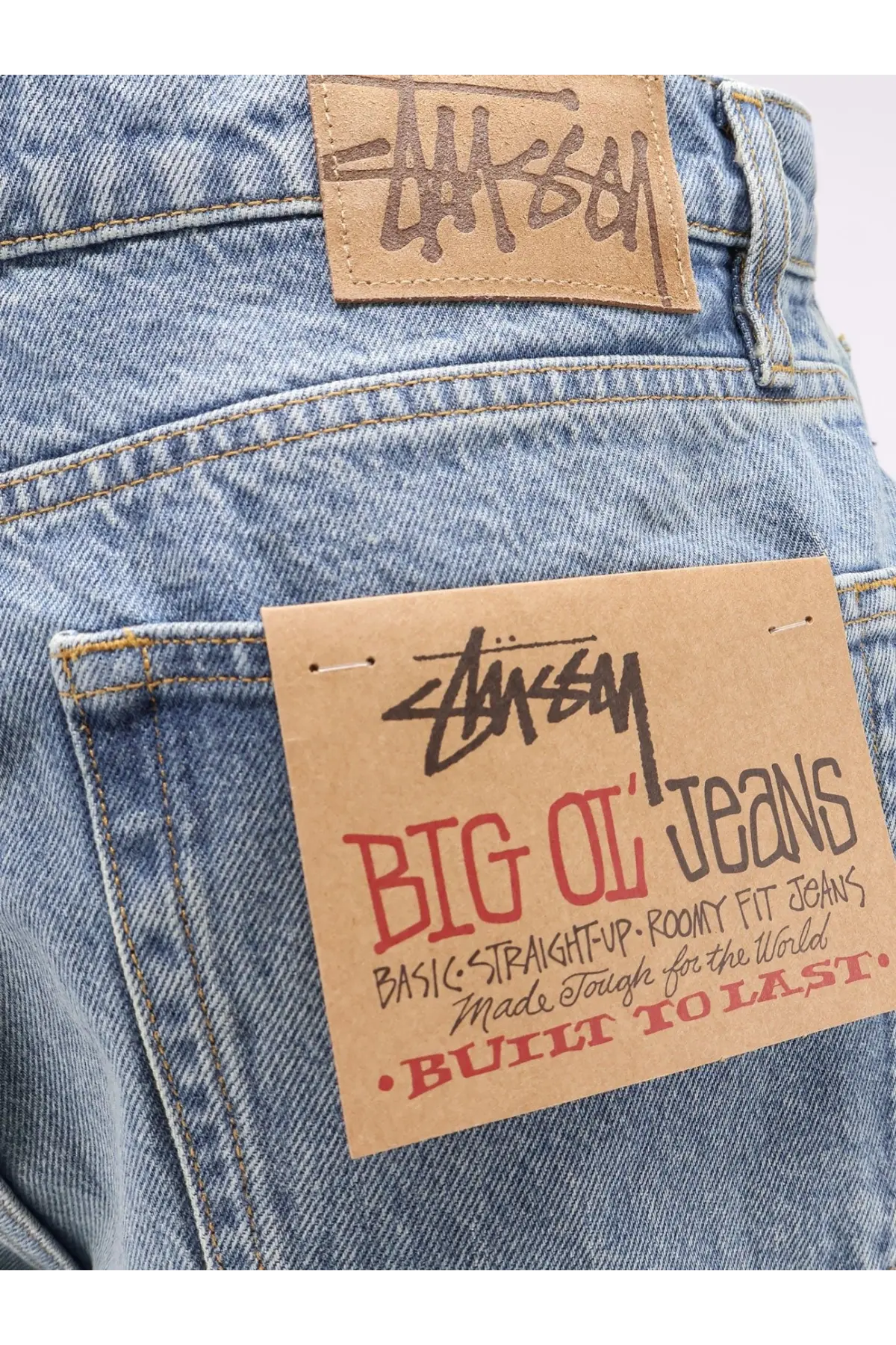 Stussy men’s big ol jean blue light-wash denim with classic straight fit and brown leather brand patch back side view