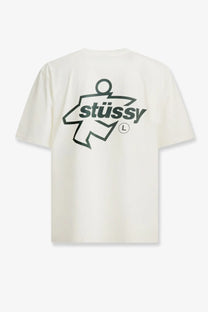 Cream-colored stussy men’s cotton t-shirt with bold black stylized figure graphic and stussy lettering in white