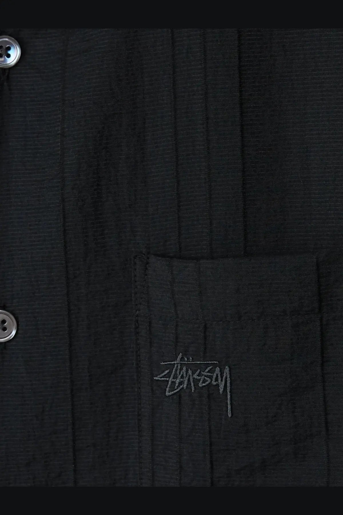 Black Stussy men’s button-up shirt made of lyocell and nylon blend with subtle embroidered logo on chest pocket