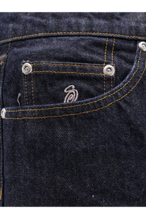 Dark blue denim jeans pocket with silver metal rivets and subtle embroidered logo on stussy mens new classic jeans back side