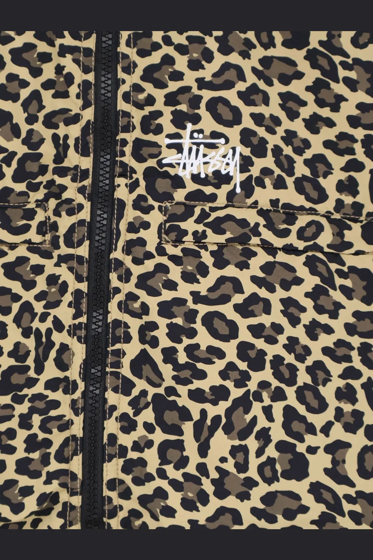 Beige and black leopard-print stussy men’s nylon jacket with a white logo patch on the chest