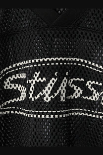 Black mesh Stussy men’s perforated nylon athletic jersey with white stitched logo and dotted outline